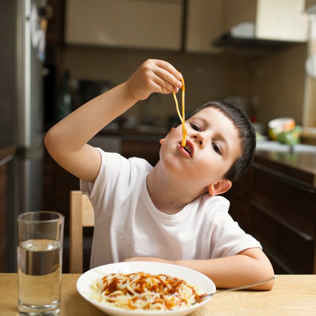 Человек кушает руками. Мальчик ест макароны. Ребенок ест макароны. Ребенок завтракает. Малыш ест спагетти.